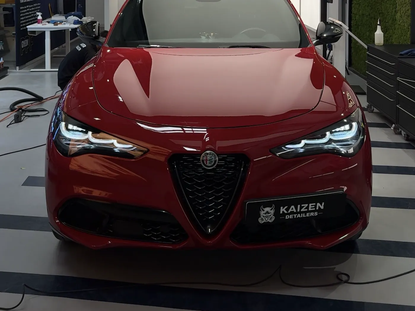 Керамическое покрытие в студии Kaizen Detailers — красный автомобиль под инспекционным светом